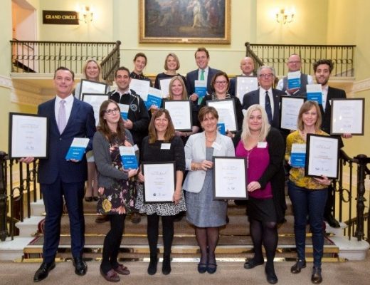 A large group of people posing for a photo with award certificates